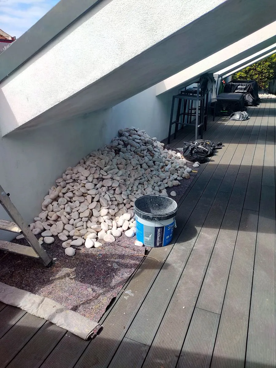 Terraço antes da intervenção, com deck degradado e seixo acumulado
